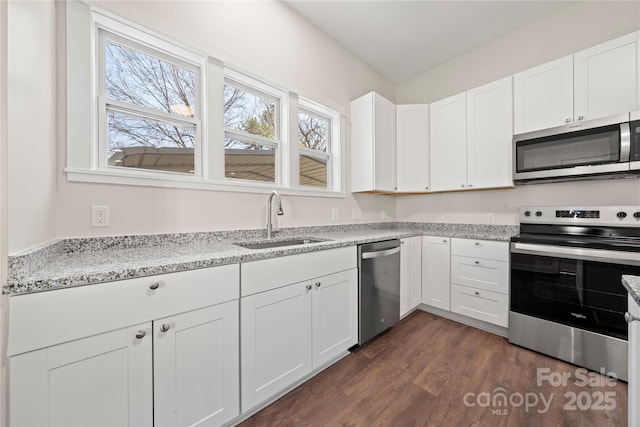 kitchen with white cabinets, appliances with stainless steel finishes, dark wood-type flooring, and a sink