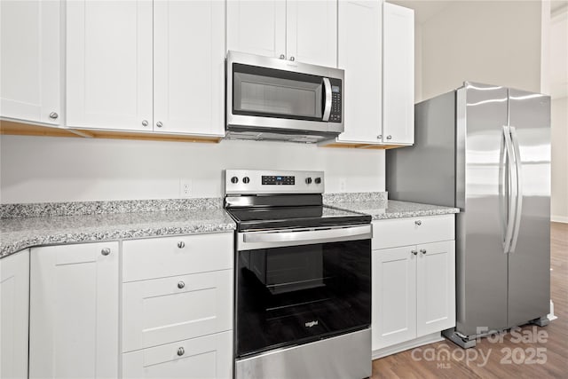 kitchen with white cabinetry, appliances with stainless steel finishes, and light wood finished floors