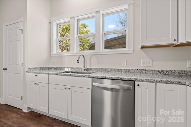 kitchen with a sink, stainless steel dishwasher, white cabinetry, light stone countertops, and dark wood-style flooring