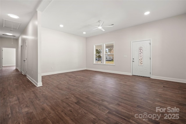 interior space featuring baseboards, attic access, dark wood-type flooring, and a ceiling fan