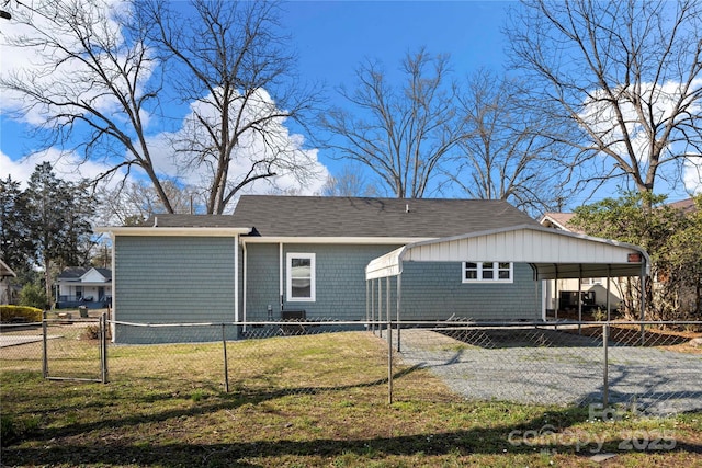 view of front of home with a carport, fence private yard, and a front lawn