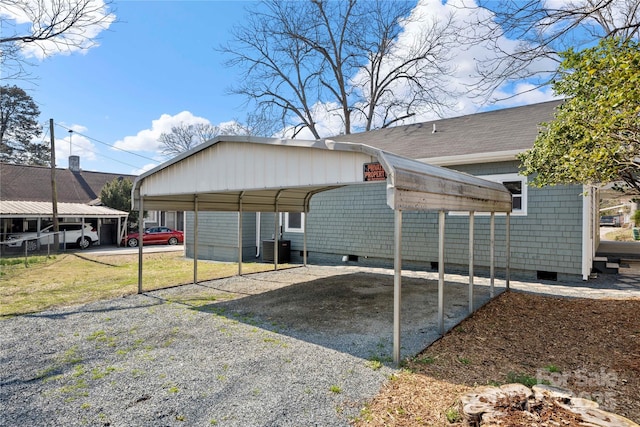 exterior space with gravel driveway, a carport, central AC, and crawl space