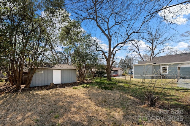 view of yard with a storage unit, an outdoor structure, and fence