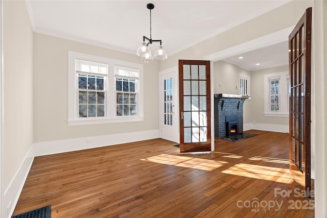 interior space with visible vents, french doors, crown molding, and hardwood / wood-style floors