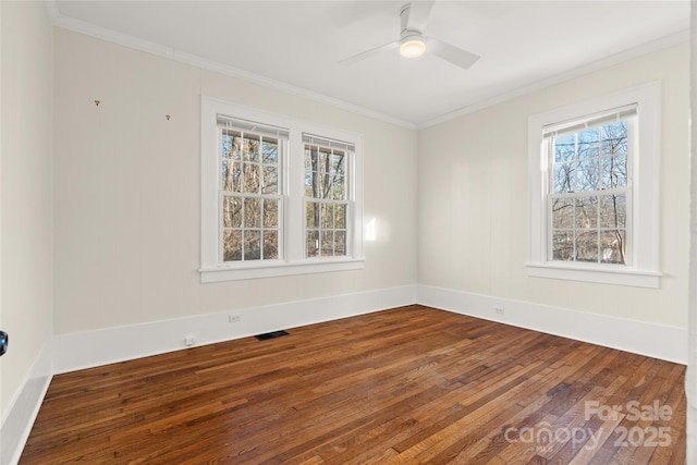 empty room with visible vents, wood-type flooring, a ceiling fan, and ornamental molding