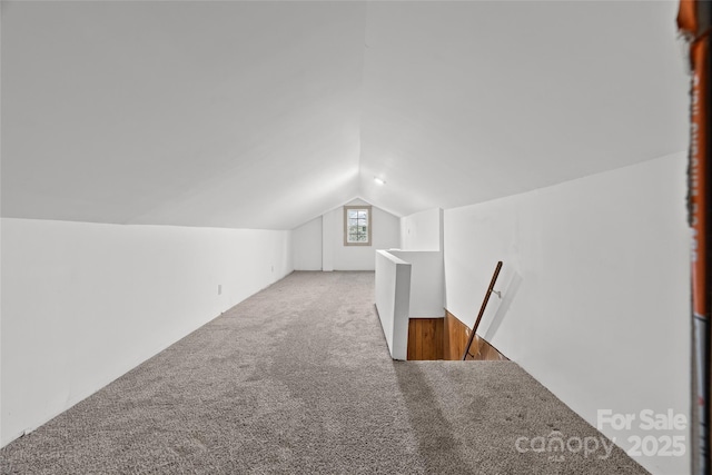 bonus room with lofted ceiling and carpet flooring