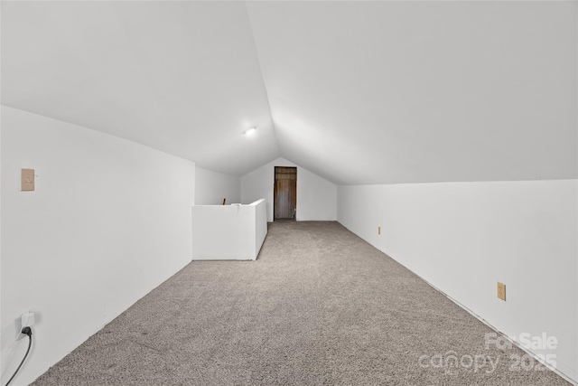 additional living space with light colored carpet and lofted ceiling