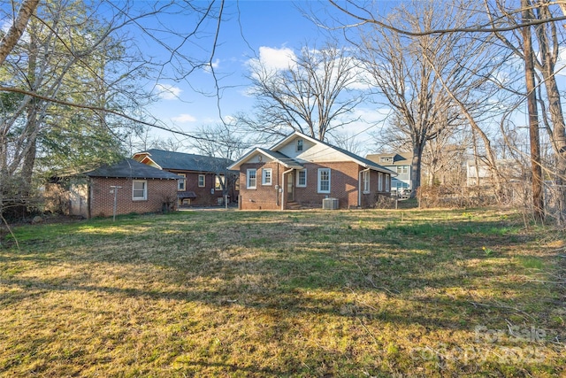 bungalow-style home featuring brick siding, crawl space, cooling unit, and a front yard