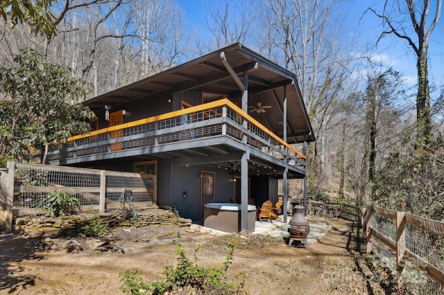 back of house with a patio, a hot tub, a ceiling fan, and fence