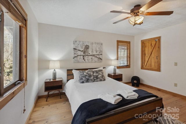 bedroom featuring light wood-type flooring, baseboards, and ceiling fan