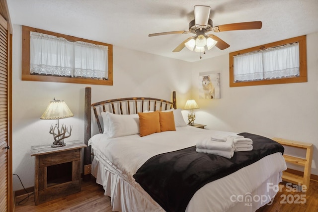 bedroom featuring a closet, wood finished floors, and a ceiling fan