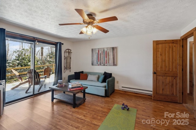 living room with a textured ceiling, ceiling fan, wood finished floors, and a baseboard radiator