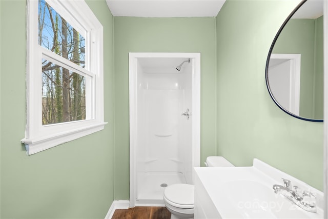 bathroom with vanity, toilet, wood finished floors, and a stall shower