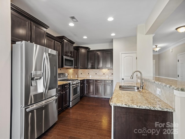 kitchen featuring tasteful backsplash, visible vents, dark wood-style floors, stainless steel appliances, and a sink