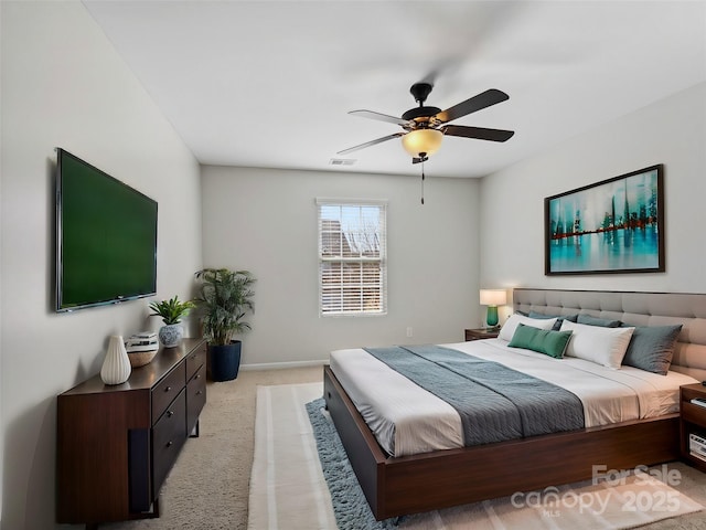 bedroom featuring visible vents, light carpet, baseboards, and a ceiling fan