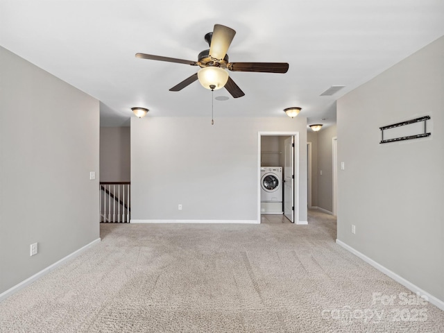 spare room with washer / dryer, a ceiling fan, baseboards, and carpet floors