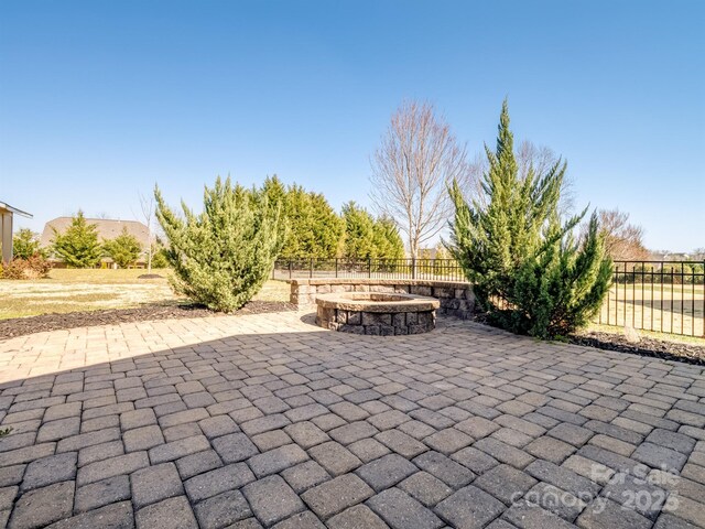 view of patio featuring an outdoor fire pit and fence