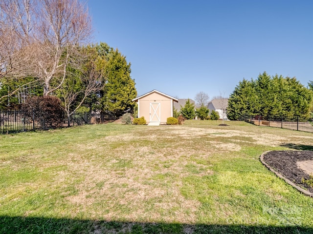 view of yard featuring fence, an outbuilding, and a shed