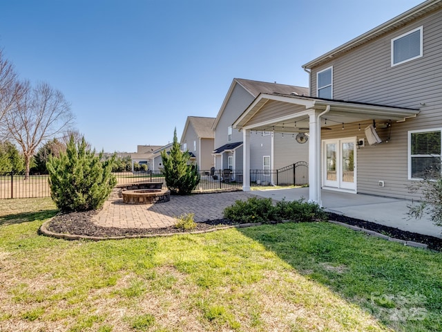 view of yard featuring french doors, a patio, a fire pit, and fence