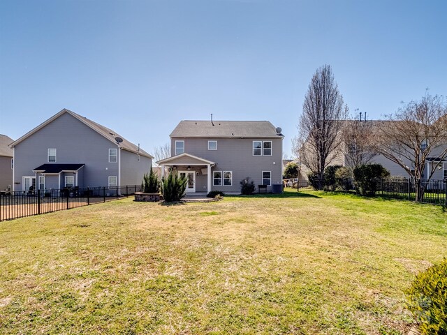 rear view of house featuring a fenced backyard, a patio area, and a yard