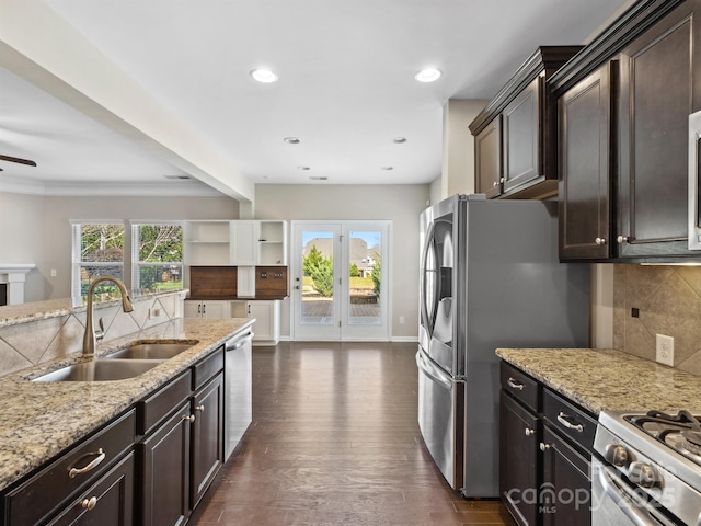 kitchen with a wealth of natural light, a sink, backsplash, appliances with stainless steel finishes, and dark wood-style flooring