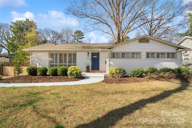 single story home featuring brick siding, a front lawn, and fence