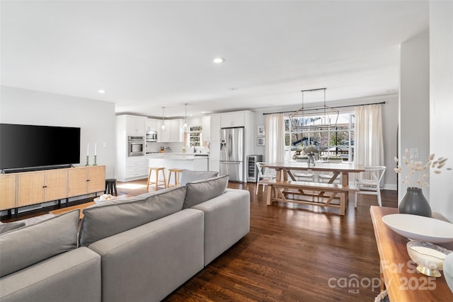 living room featuring recessed lighting, baseboards, and dark wood-style flooring