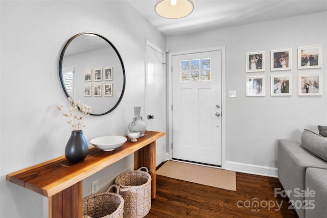 entryway featuring dark wood finished floors and baseboards