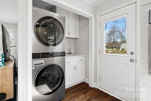 washroom with cabinet space, plenty of natural light, dark wood-style floors, and stacked washer / dryer