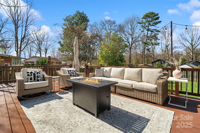 deck featuring an outdoor living space with a fire pit