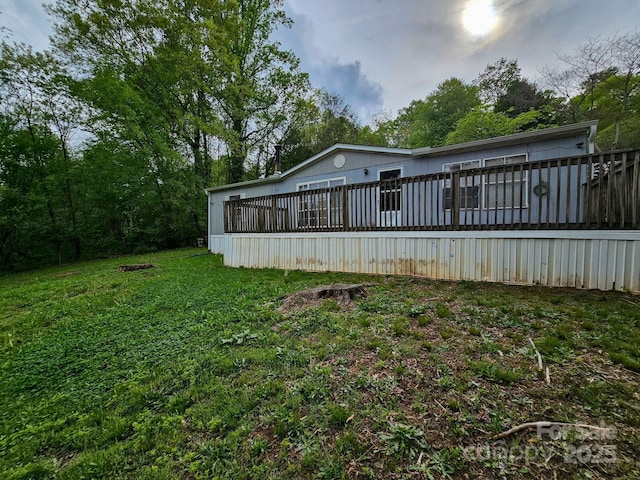 rear view of house with a wooden deck and a yard