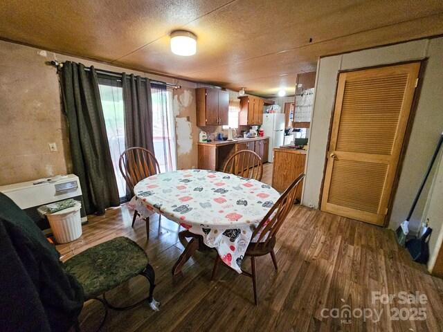 dining room with a textured ceiling and wood finished floors