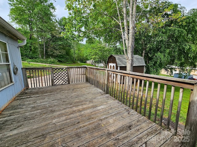 wooden deck with a storage shed and an outbuilding
