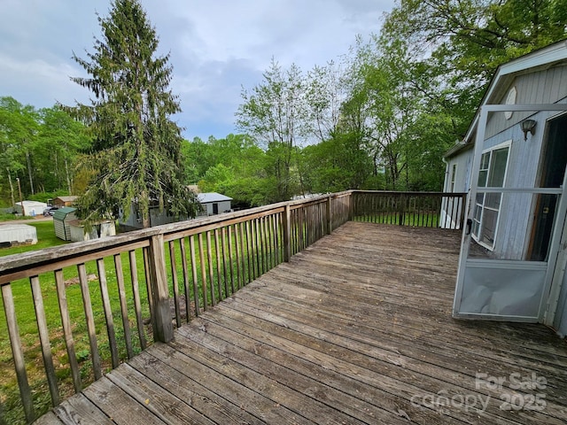 wooden terrace with a lawn