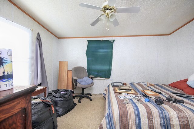 bedroom featuring a textured ceiling, crown molding, a ceiling fan, and carpet floors