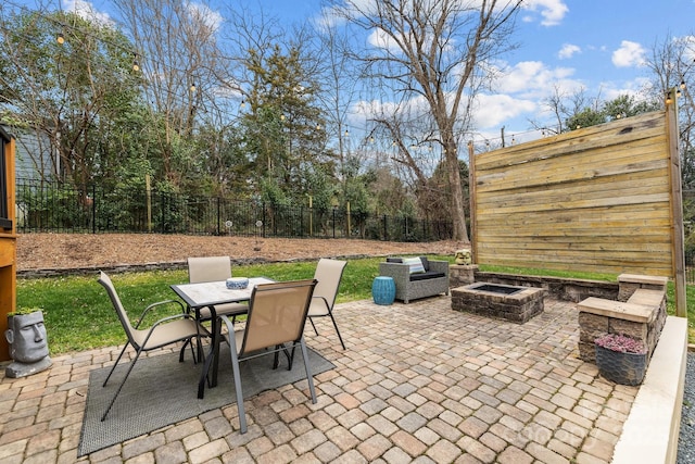 view of patio featuring outdoor dining space, fence, and an outdoor fire pit