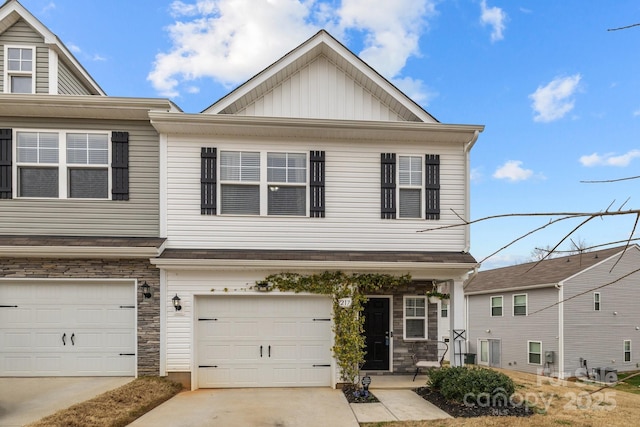 multi unit property with board and batten siding, concrete driveway, a garage, and stone siding