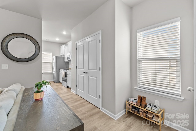 living room with recessed lighting, baseboards, and light wood finished floors