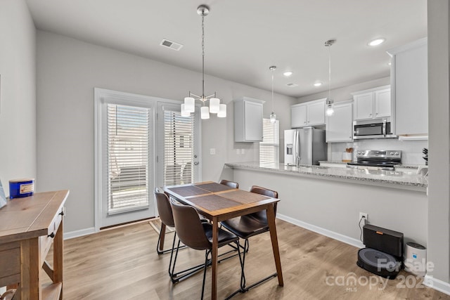 dining room with light wood finished floors, visible vents, recessed lighting, and baseboards