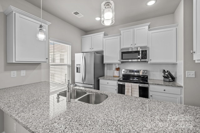 kitchen with a sink, white cabinets, backsplash, and stainless steel appliances