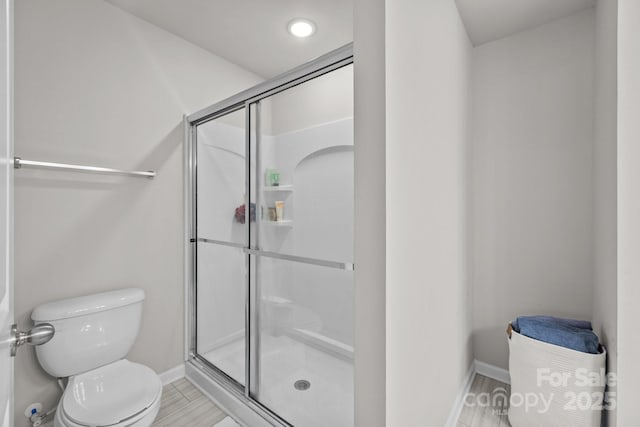 full bath featuring baseboards, toilet, and a stall shower