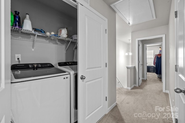 laundry area with baseboards, light colored carpet, washing machine and dryer, attic access, and laundry area