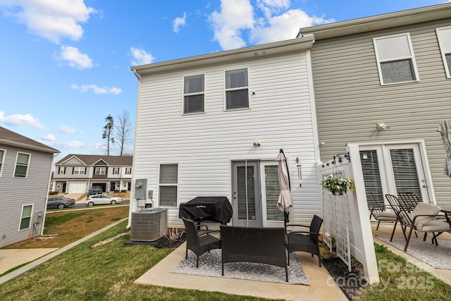 rear view of property with an outdoor living space, a yard, a patio, and central AC