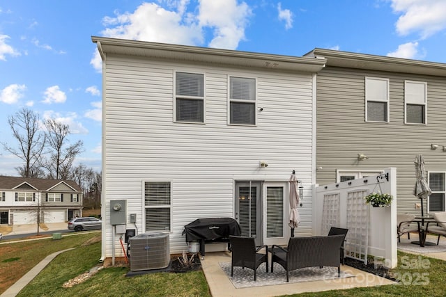 rear view of property featuring a yard, a patio area, central AC, and an outdoor hangout area