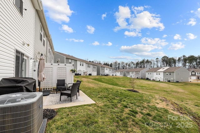 view of yard featuring a patio area, a residential view, and central AC