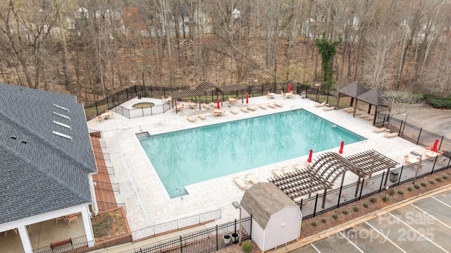 community pool with a patio area, a pergola, and fence