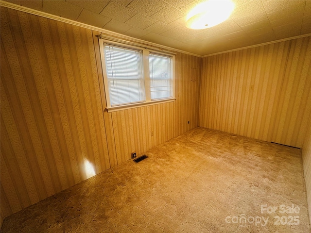 carpeted empty room with visible vents and ornamental molding