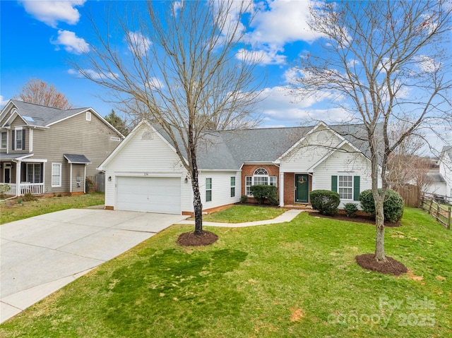 view of front facade with a front lawn, driveway, fence, an attached garage, and brick siding