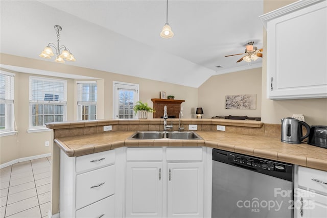 kitchen with lofted ceiling, a sink, white cabinets, pendant lighting, and dishwasher