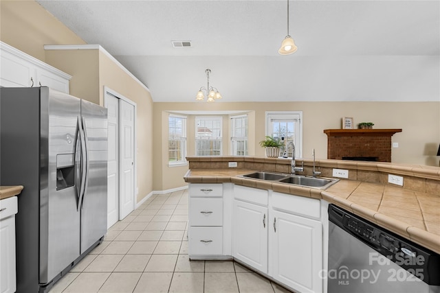 kitchen featuring visible vents, lofted ceiling, light tile patterned floors, appliances with stainless steel finishes, and a sink